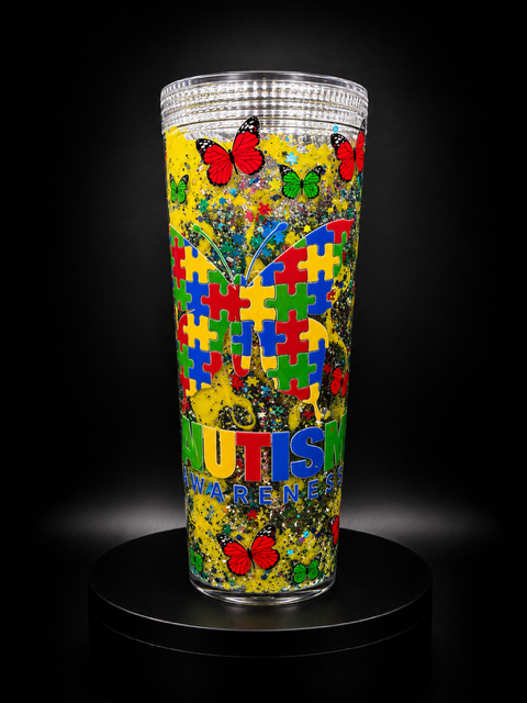 Tumbler de Autism Awareness con mariposas y rompecabezas sobre fondo amarillo con glitter